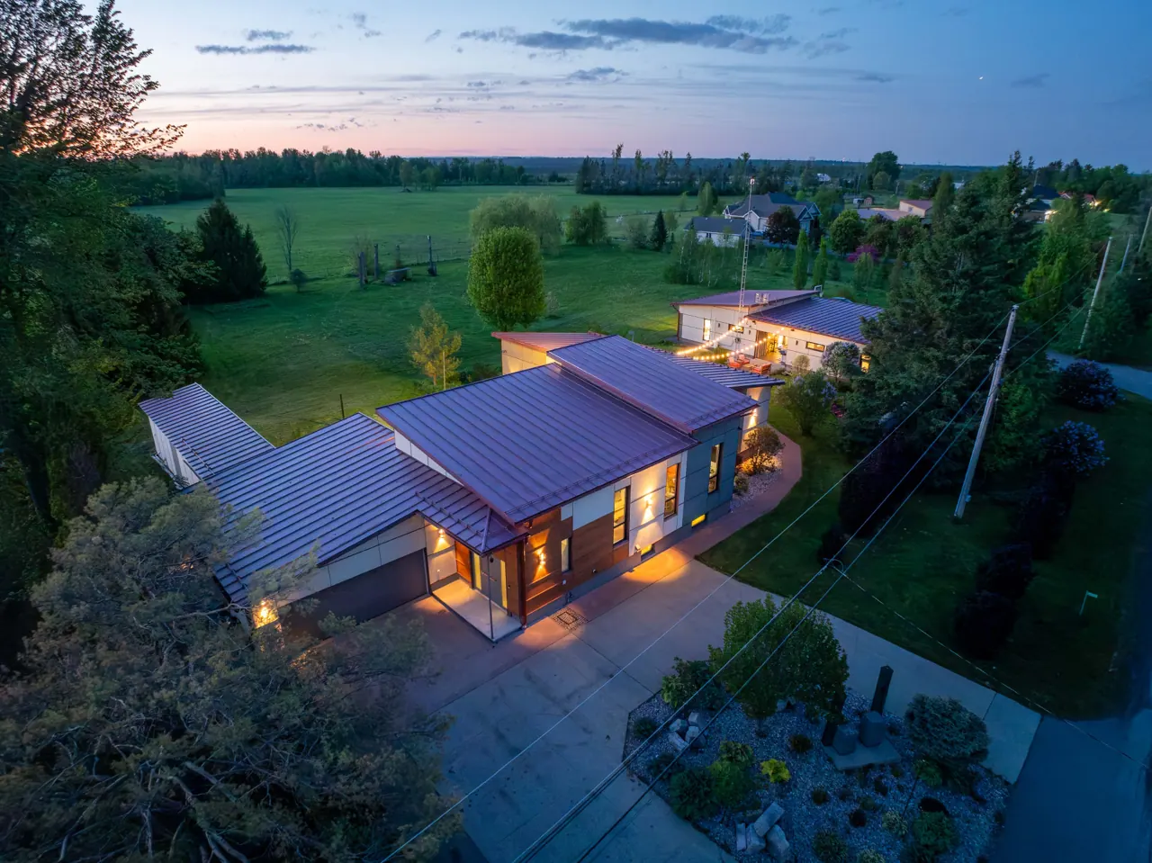 Aerial view of a modern home with metal roofing at dusk — GCO residential work in Ottawa