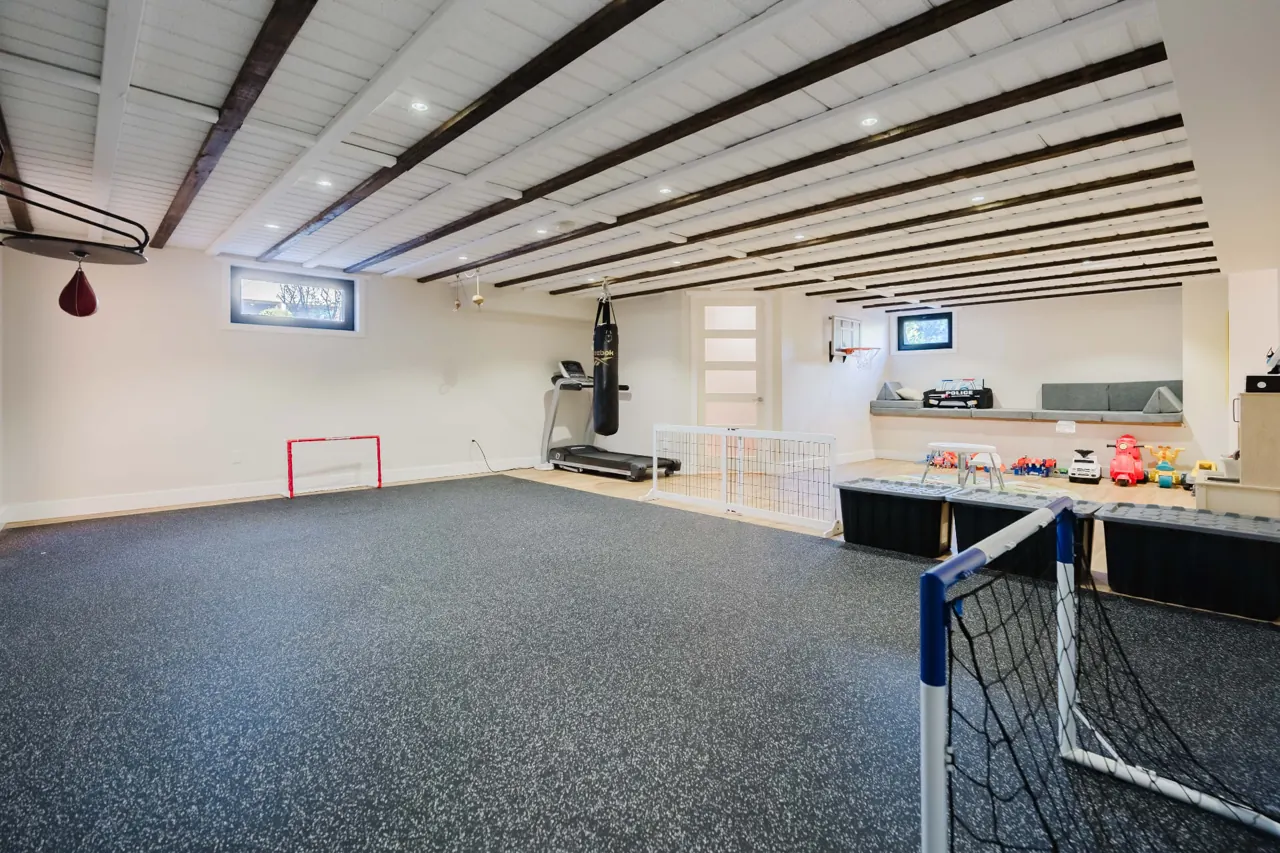 Basement recreation room with exercise equipment and play space — GCO basement work in Ottawa