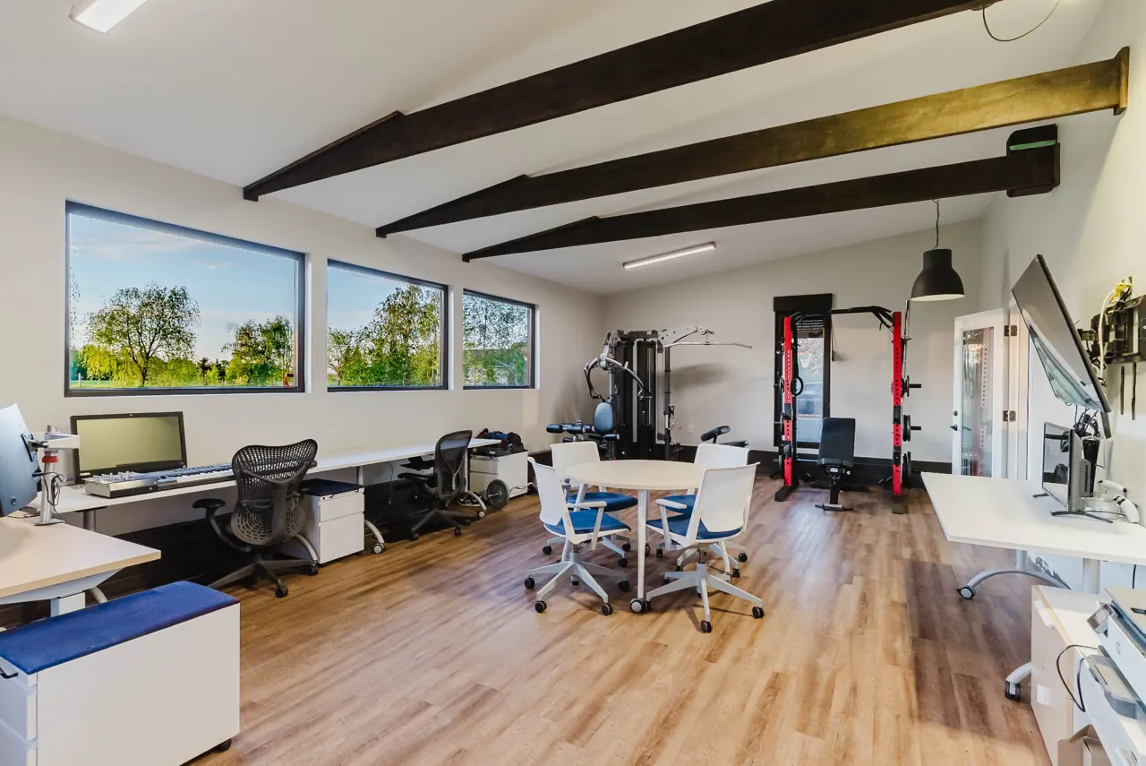Workspace with desks, exposed beams and exercise equipment — GCO interior work in Ottawa