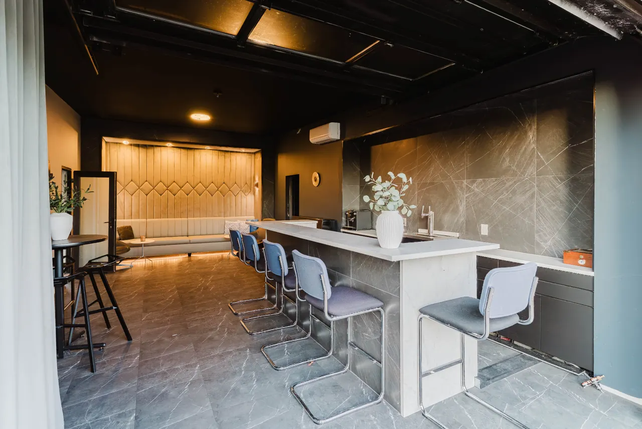 Lounge interior with a stone-look counter, blue chairs and upholstered seating — GCO work in Ottawa