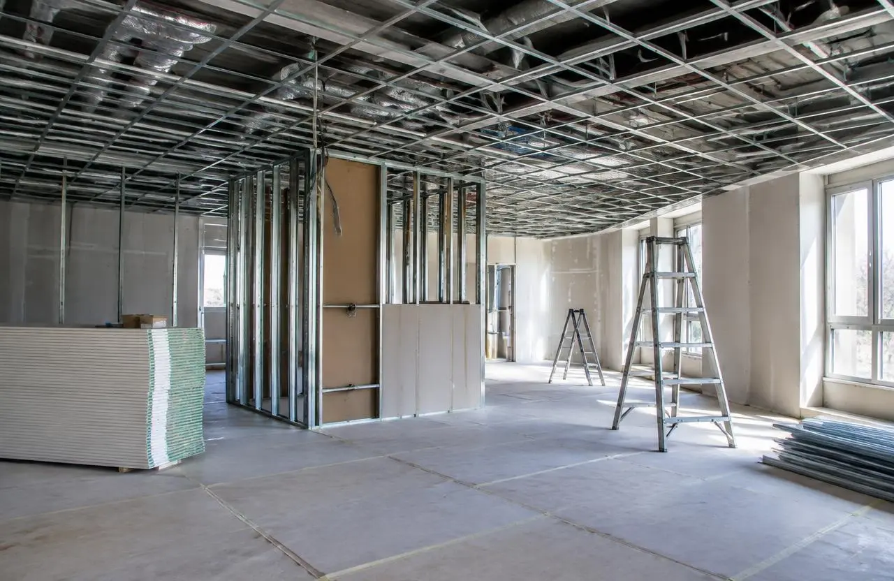 Illustrative interior under construction with steel stud partitions and an open ceiling grid