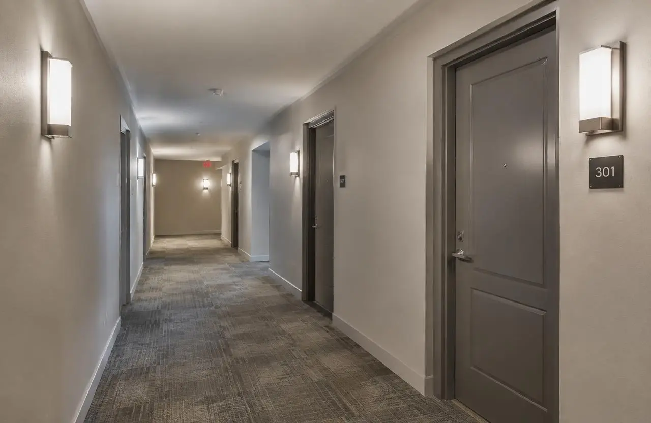 Illustrative residential building corridor with carpet tile and wall sconces